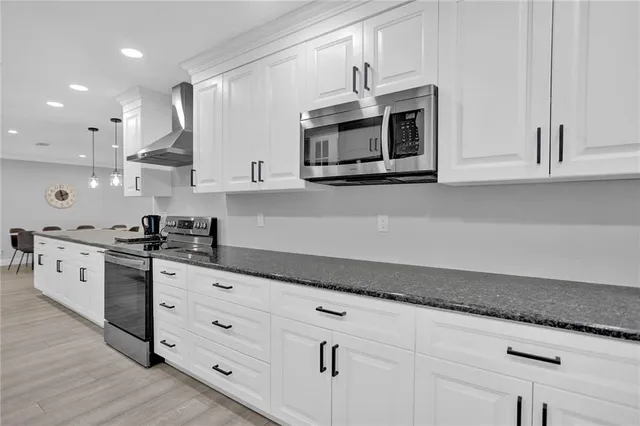 a kitchen with stainless steel appliances granite countertop a sink a stove and microwave