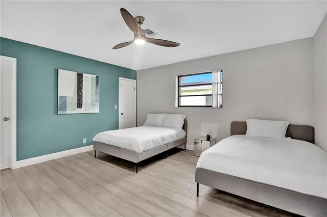 a bedroom with two beds and painting on the wall