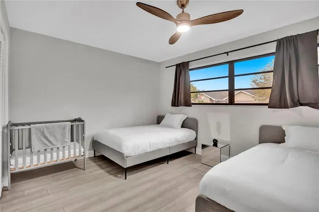 a bedroom with two beds and a ceiling fan