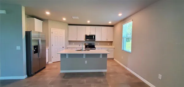 a kitchen with stainless steel appliances granite countertop a refrigerator sink and microwave