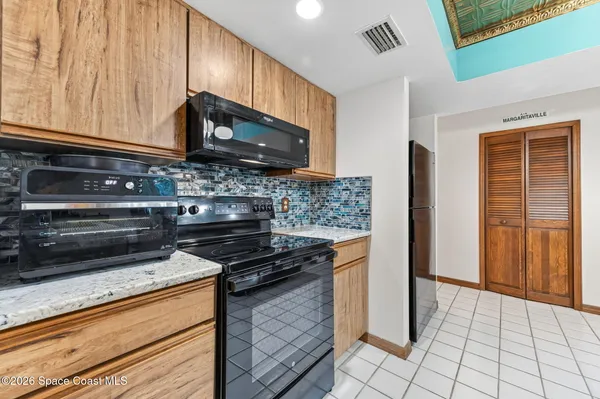 a kitchen with stainless steel appliances granite countertop a stove refrigerator and cabinets