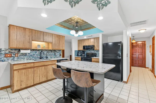 a kitchen with stainless steel appliances kitchen island granite countertop a table chairs in it and wooden floors