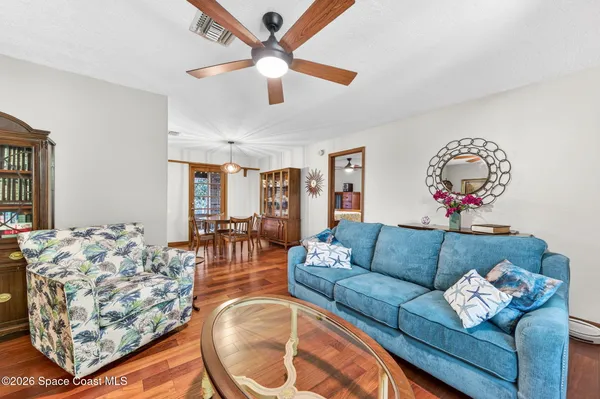a living room with furniture kitchen view and a large window