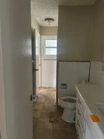 a bathroom with a granite countertop toilet and a sink