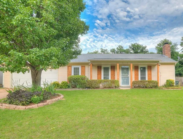 a front view of a house with a garden