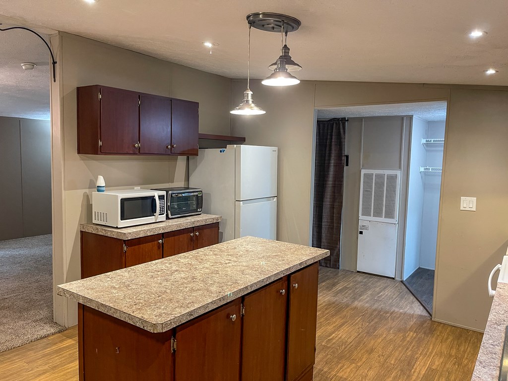 89 Kanati Trail Murphy, NC 28906 - Photo 10 of 30 a kitchen with a sink a kitchen island a refrigerator and wooden cabinets