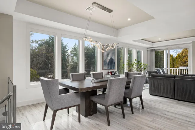 a kitchen with stainless steel appliances kitchen island granite countertop a dining table chairs and a refrigerator