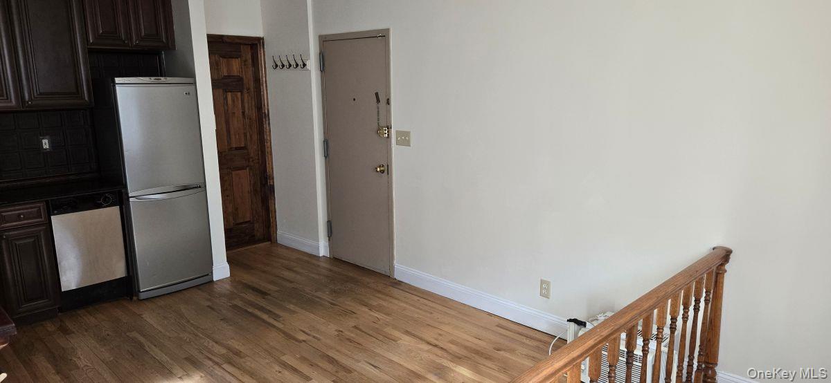 235 West 137th Street, Unit 1F Manhattan, NY 10030 - Photo 15 of 27 a view of a hallway with wooden floor and a refrigerator