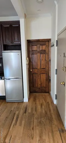 an empty room with wooden floor and cabinet
