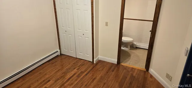 an empty room with wooden floor and mirror