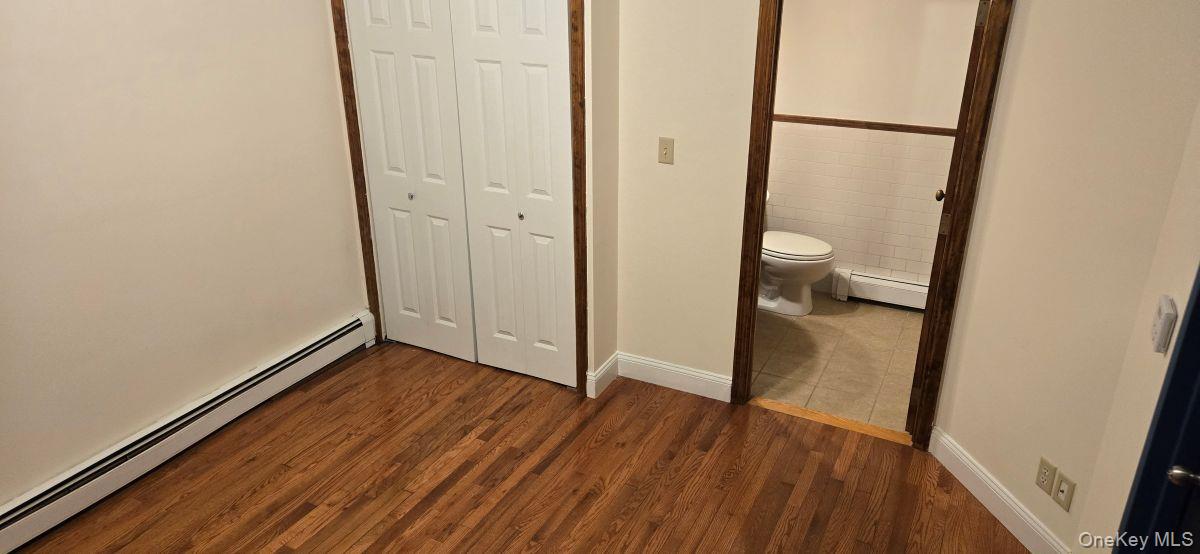 235 West 137th Street, Unit 1F Manhattan, NY 10030 - Photo 21 of 27 an empty room with wooden floor and mirror