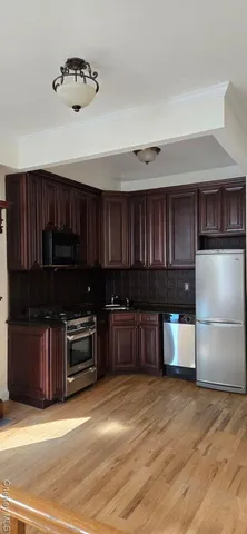 a kitchen with stainless steel appliances granite countertop a refrigerator a stove a sink and cabinets