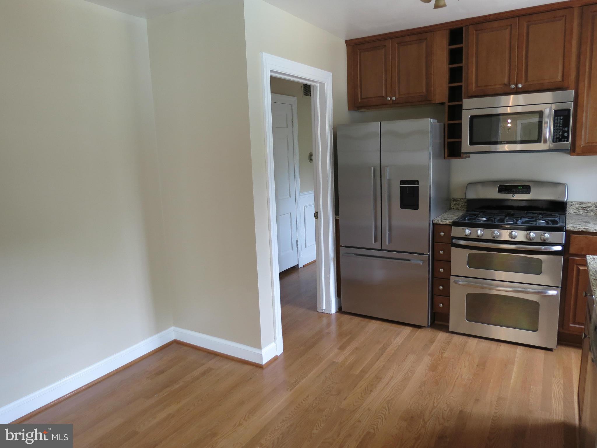 809 Orchard Way Silver Spring, MD 20904 - Photo 14 of 30 a kitchen with granite countertop a refrigerator and a stove top oven