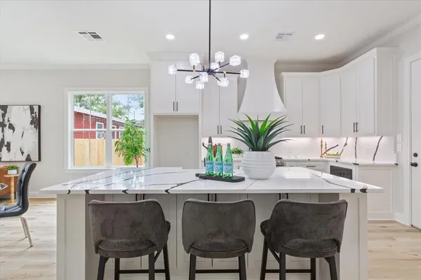 a dining room with furniture a potted plant and a chandelier