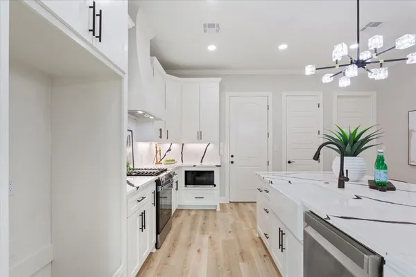 a kitchen with a white stove top oven and white cabinets
