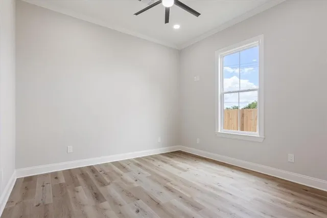 an empty room with a window and a ceiling fan