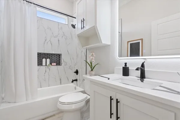 a bathroom with a sink a toilet and shower