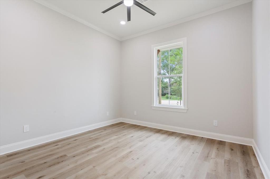 107 North Jena Street Riesel, TX 76682 - Photo 25 of 34 an empty room with wooden floor ceiling fan and window