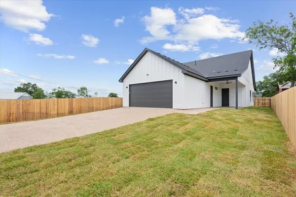 a view of a house with a backyard and a garage