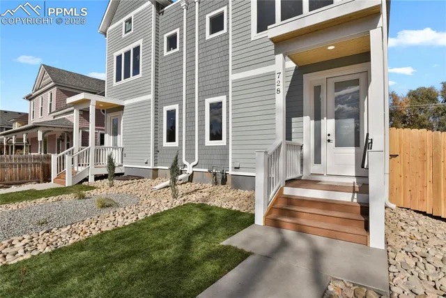 a view of a brick house with many windows and a yard