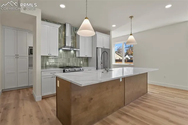 a kitchen with stainless steel appliances granite countertop a sink a stove and a refrigerator