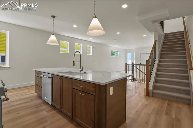 a kitchen with stainless steel appliances granite countertop a sink a oven and a refrigerator