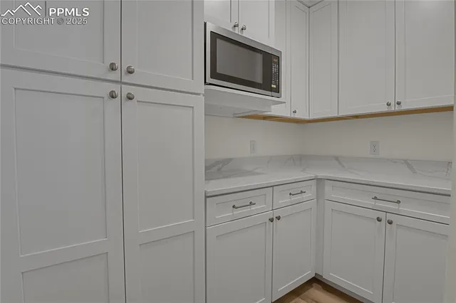 a kitchen with white cabinets and white appliances