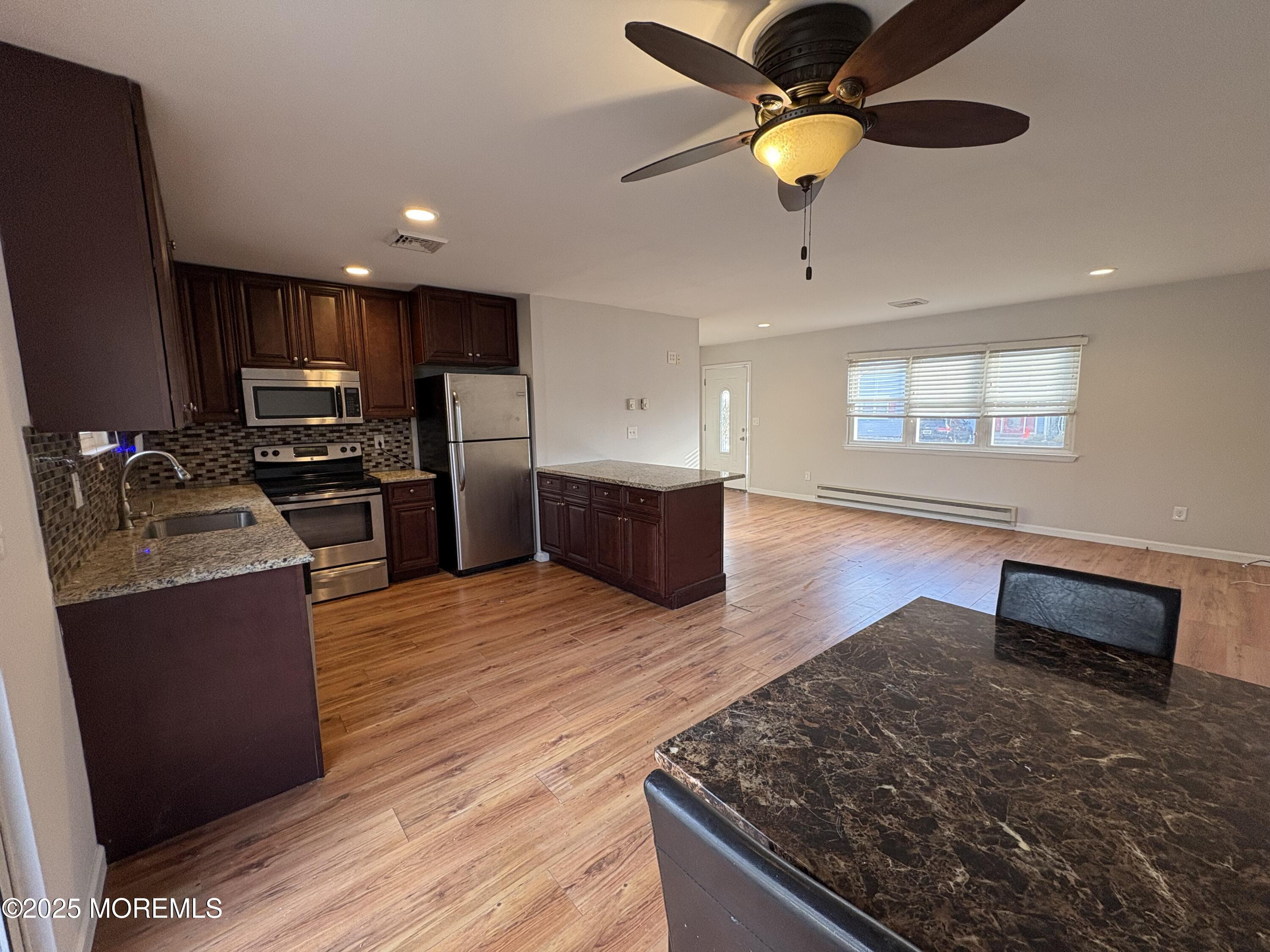 4 A Primrose Lane Jackson, NJ 08527 - Photo 4 of 14 a kitchen with stainless steel appliances granite countertop a stove refrigerator and wooden floor
