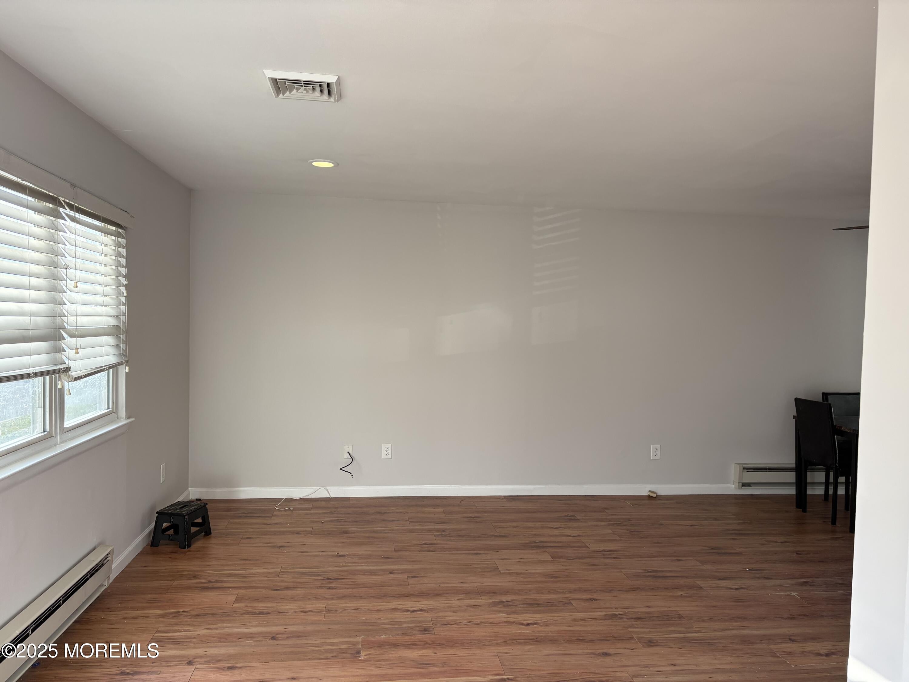 4 A Primrose Lane Jackson, NJ 08527 - Photo 8 of 14 a view of an empty room with wooden floor and a window