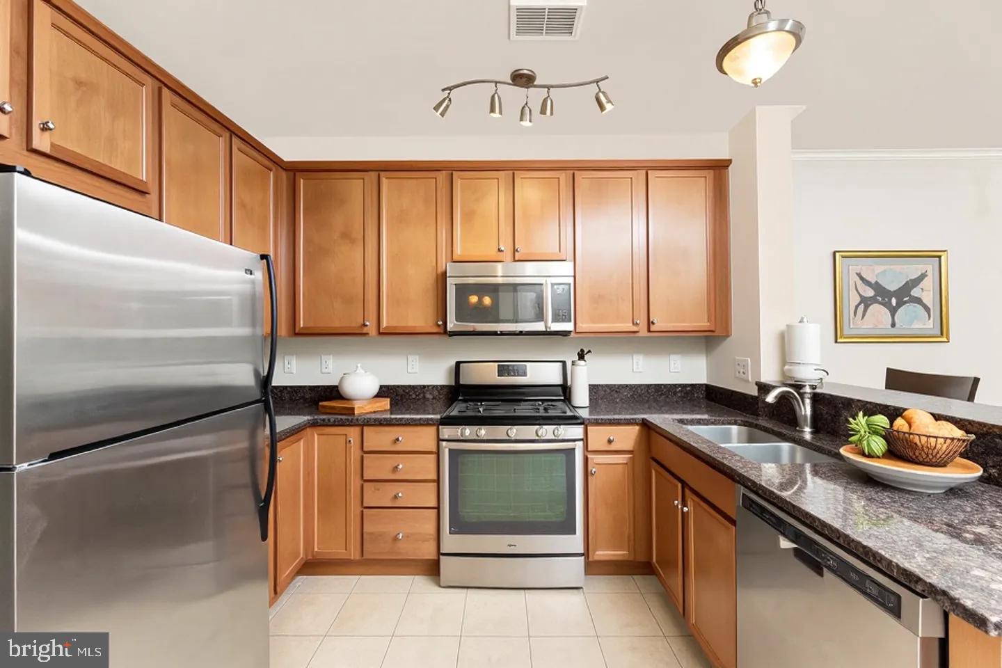 15250 Torbay Way Woodbridge, VA 22191 - Photo 7 of 31 a kitchen with granite countertop stainless steel appliances a stove sink and refrigerator