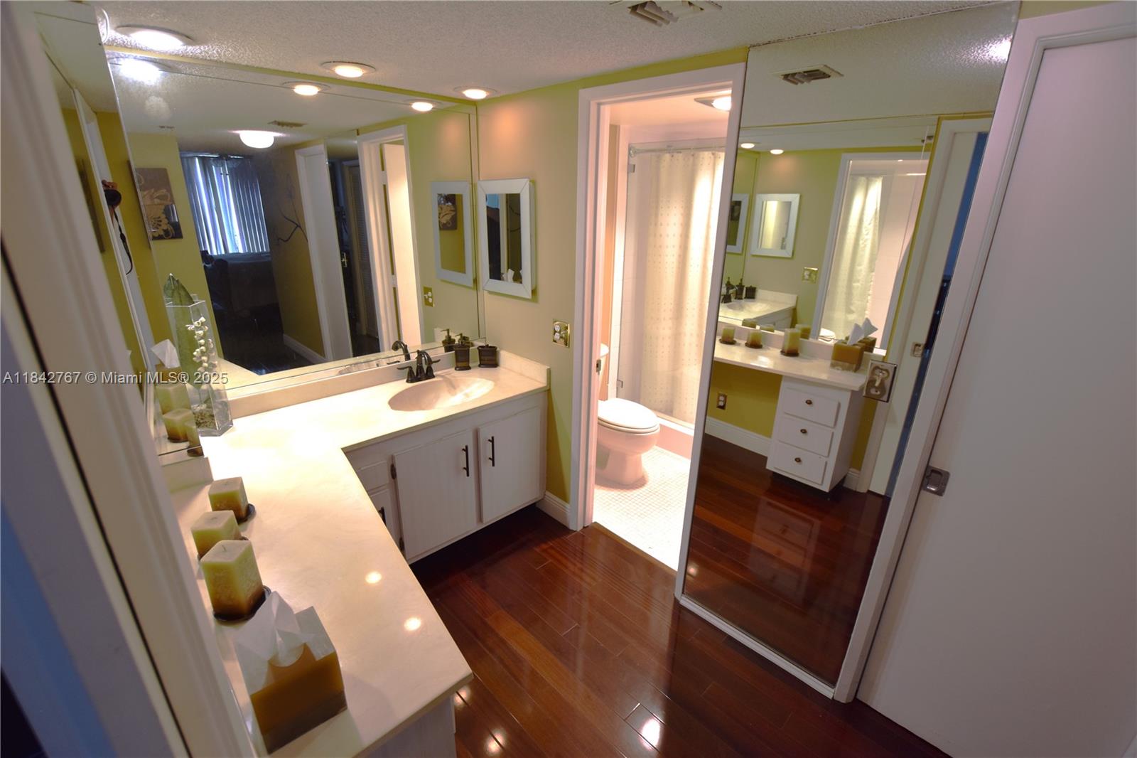 3800 Oaks Clubhouse Drive, Unit 309 Pompano Beach, FL 33069 - Photo 11 of 47 a bathroom with a double vanity sink a mirror and shower