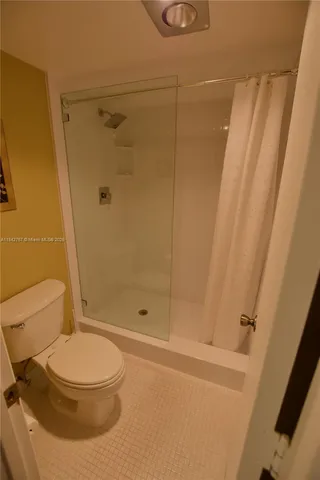 a bathroom with a toilet and a shower