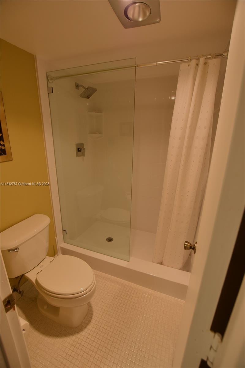 3800 Oaks Clubhouse Drive, Unit 309 Pompano Beach, FL 33069 - Photo 15 of 47 a bathroom with a toilet and a shower