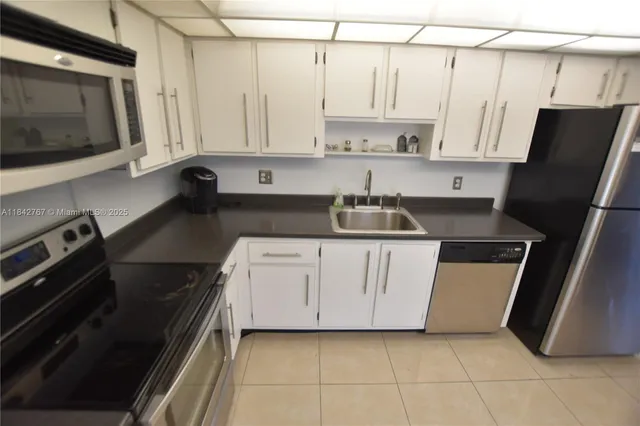 a kitchen with stainless steel appliances a refrigerator sink and microwave