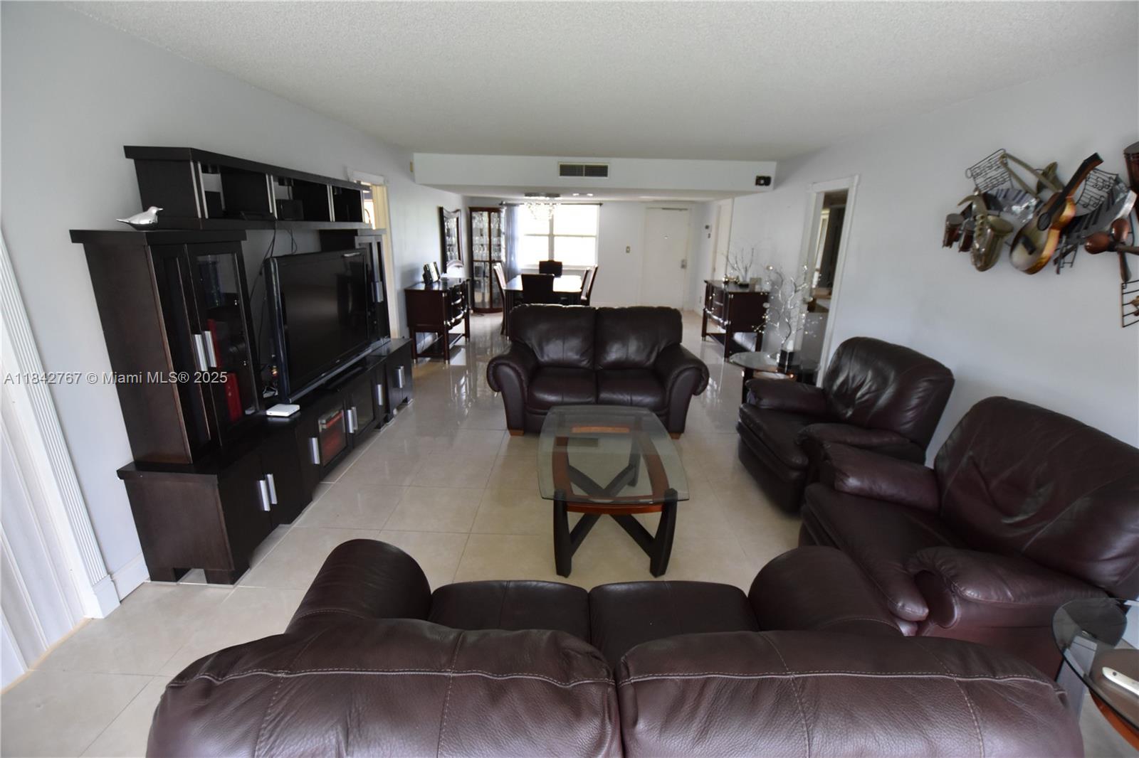 3800 Oaks Clubhouse Drive, Unit 309 Pompano Beach, FL 33069 - Photo 22 of 47 a living room with furniture and a flat screen tv