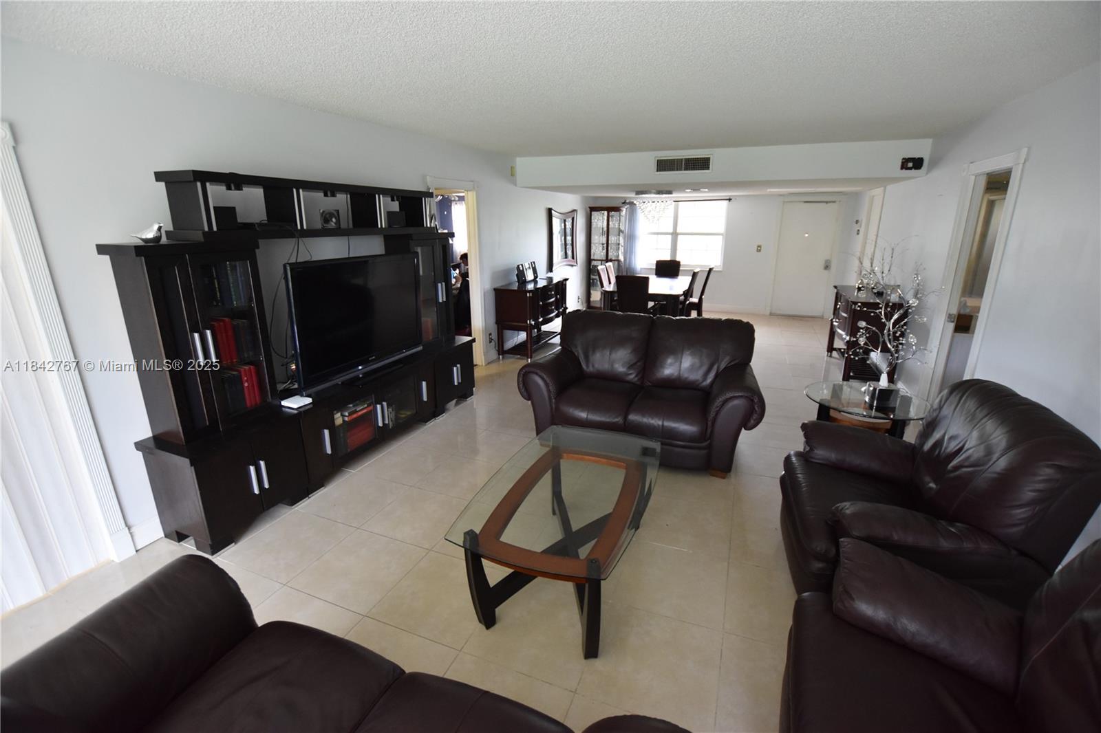 3800 Oaks Clubhouse Drive, Unit 309 Pompano Beach, FL 33069 - Photo 23 of 47 a living room with furniture and a flat screen tv