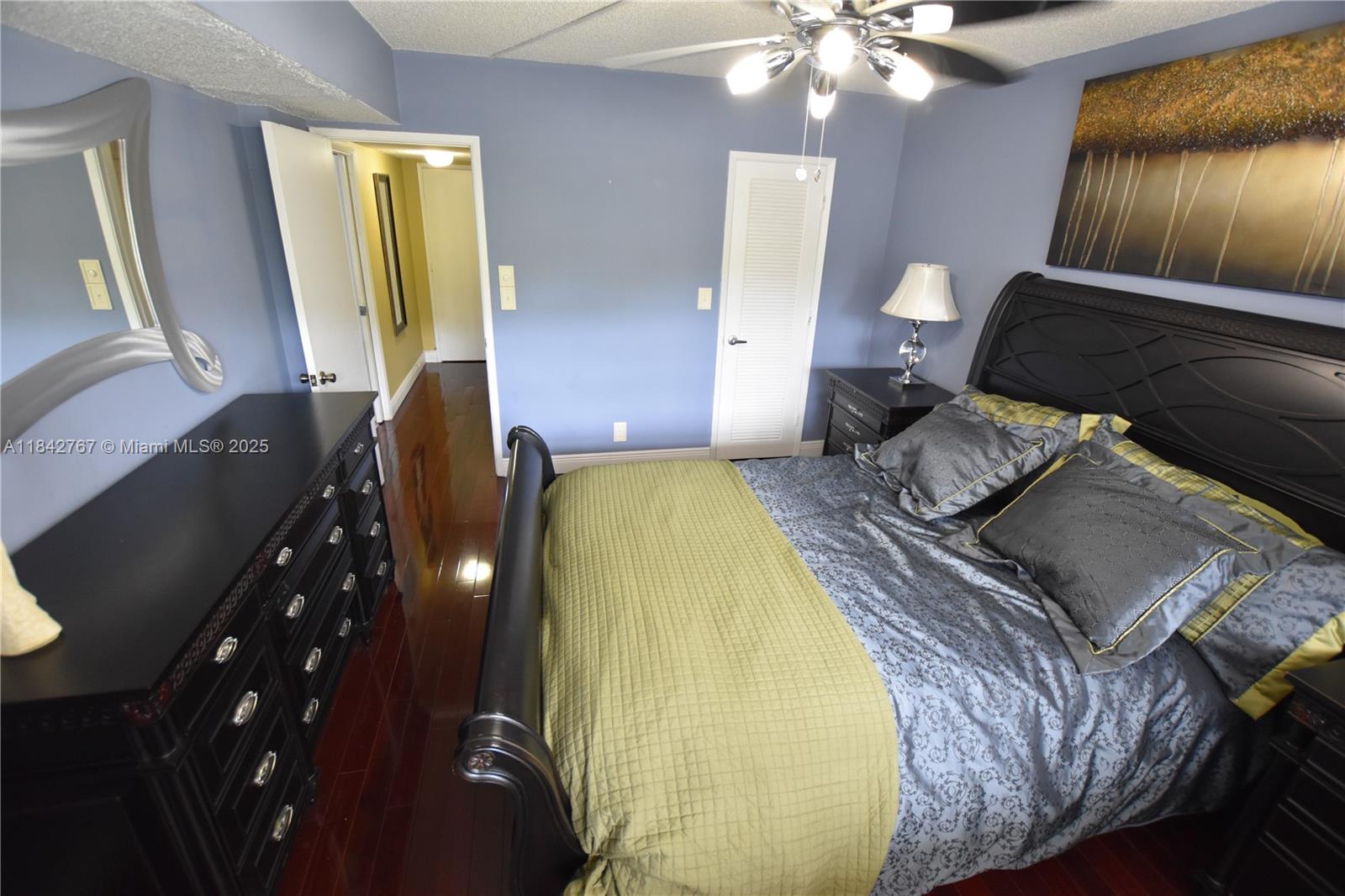 3800 Oaks Clubhouse Drive, Unit 309 Pompano Beach, FL 33069 - Photo 25 of 47 a spacious bedroom with a bed and wooden floor