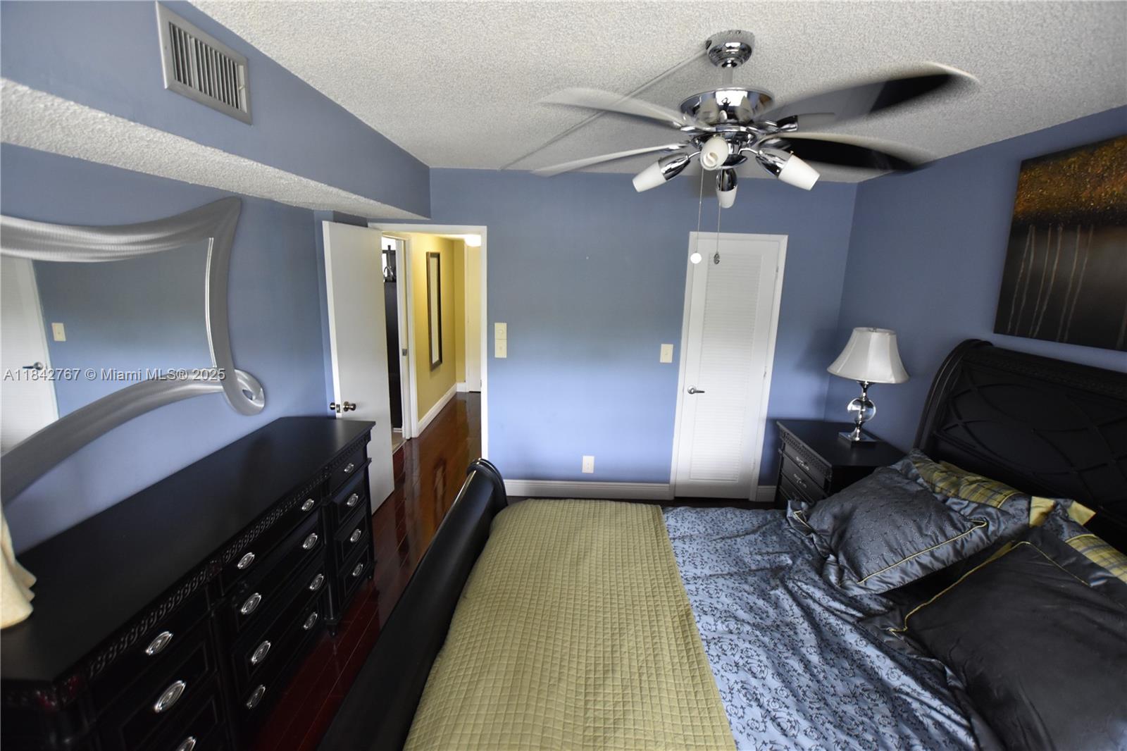3800 Oaks Clubhouse Drive, Unit 309 Pompano Beach, FL 33069 - Photo 26 of 47 a bedroom with a bed and wooden floor
