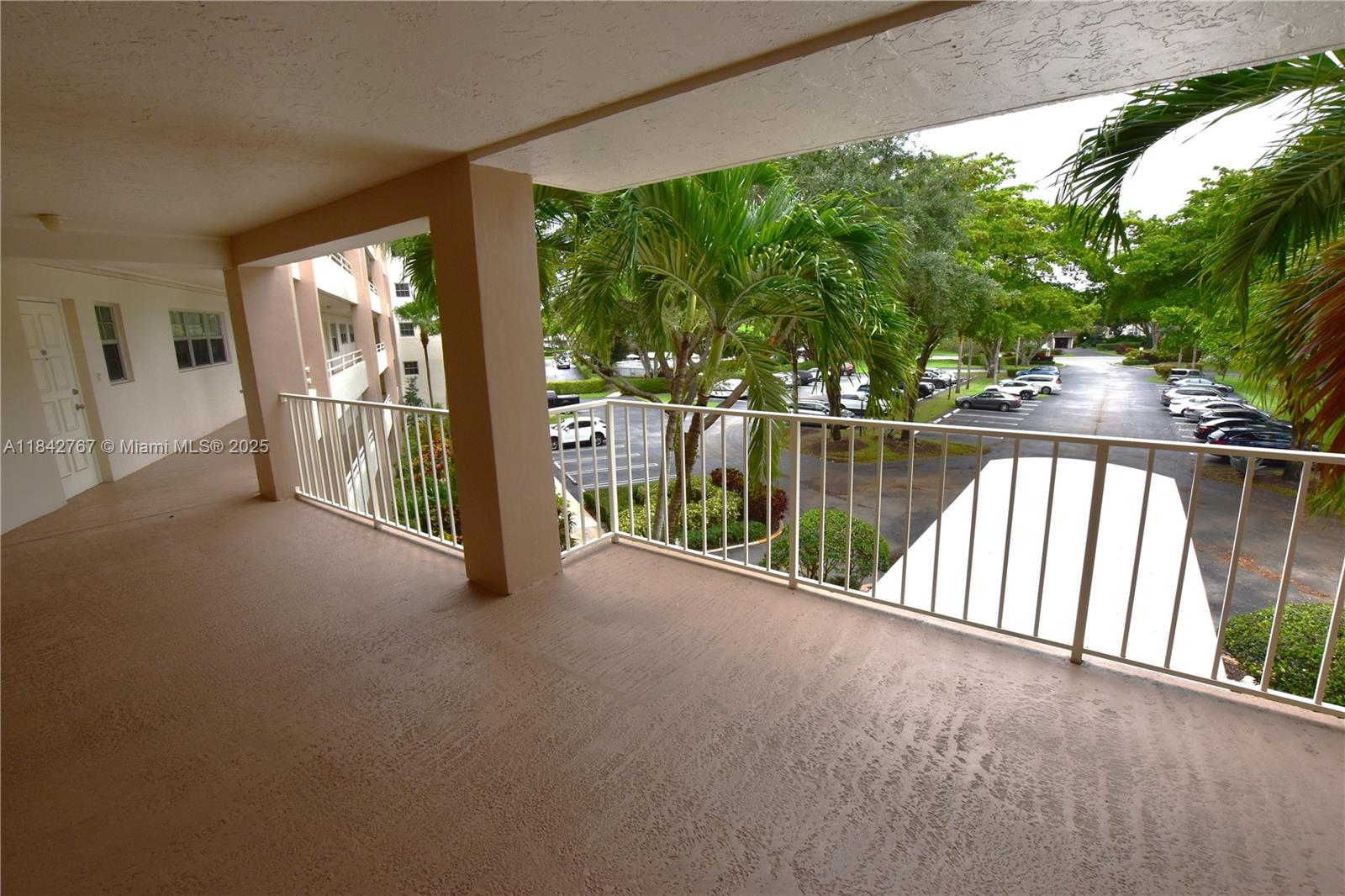 3800 Oaks Clubhouse Drive, Unit 309 Pompano Beach, FL 33069 - Photo 30 of 47 a view of a porch with couches and table and chairs next to yard