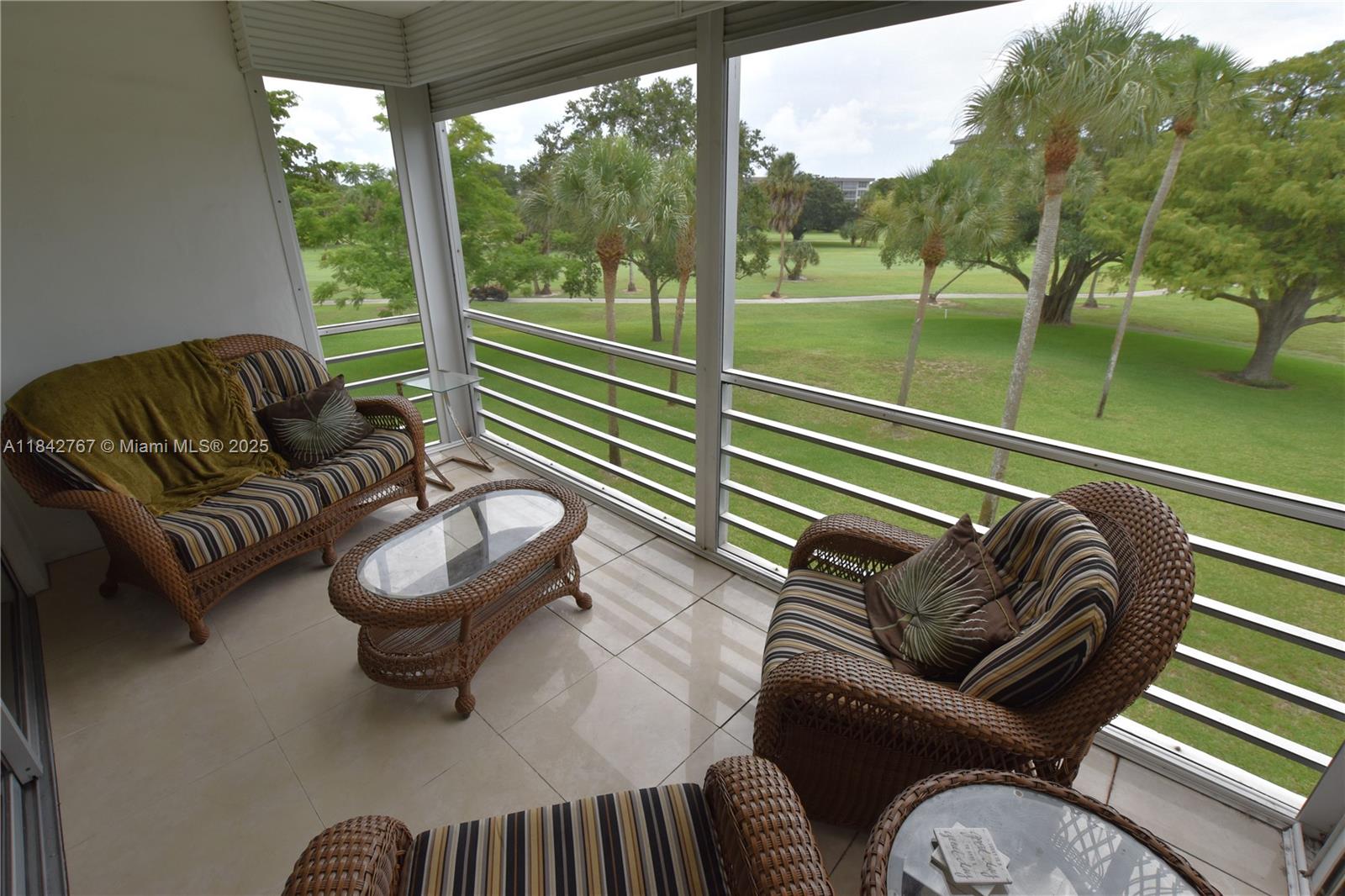 3800 Oaks Clubhouse Drive, Unit 309 Pompano Beach, FL 33069 - Photo 3 of 47 a living room with furniture and a floor to ceiling window
