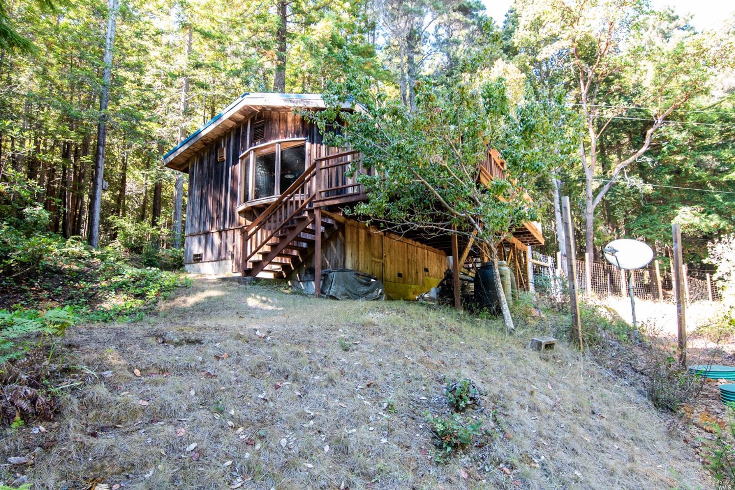 39651 Eureka Hill Road Point Arena, CA 95468 - Photo 1 of 1 a view of a wooden house with a yard and large trees