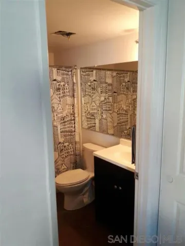 a bathroom with a granite countertop sink a toilet and shower