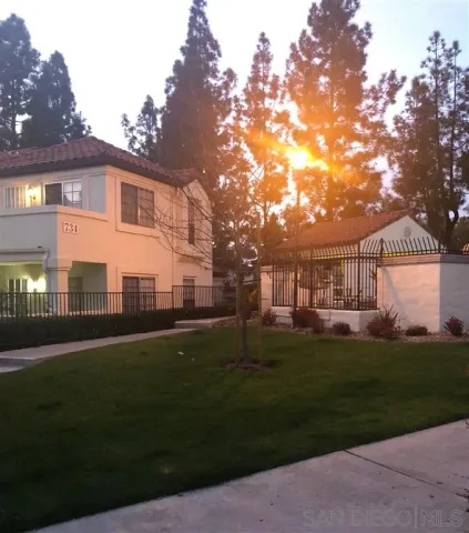 a front view of a house with a garden and trees