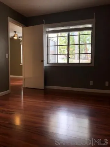 a view of a room with wooden floor and a window