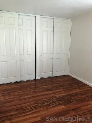 a view of wooden floor and closet in a room