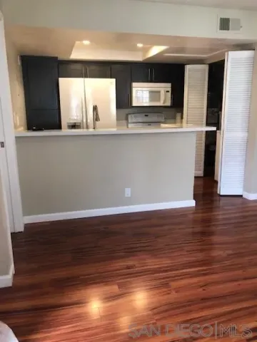 a view of a kitchen with cabinets and wooden floor