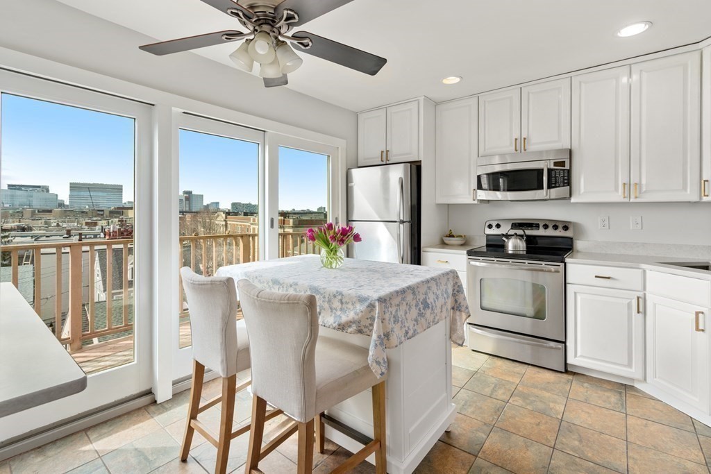 48-50 Russell Street, Unit 3A Boston, MA 02129 - Photo 2 of 11 a kitchen with stainless steel appliances granite countertop a stove a refrigerator a oven with white cabinets and wooden floor
