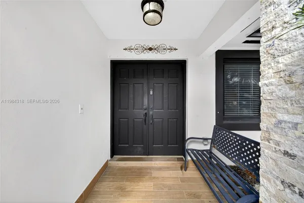 a view of a hallway with wooden floor and staircase