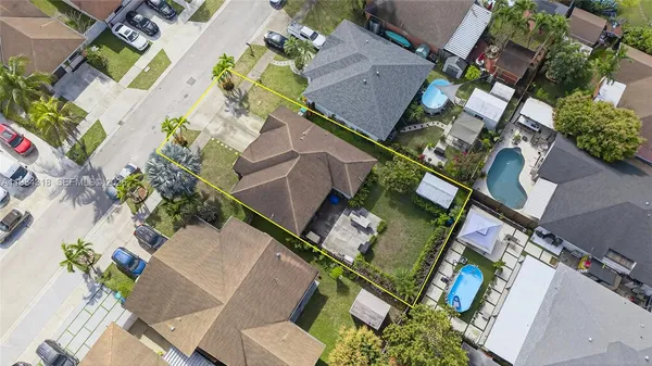 an aerial view of residential houses with outdoor space and trees
