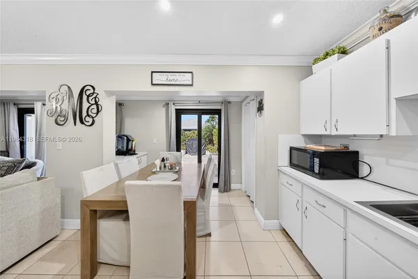 a white kitchen with a sink and white cabinets